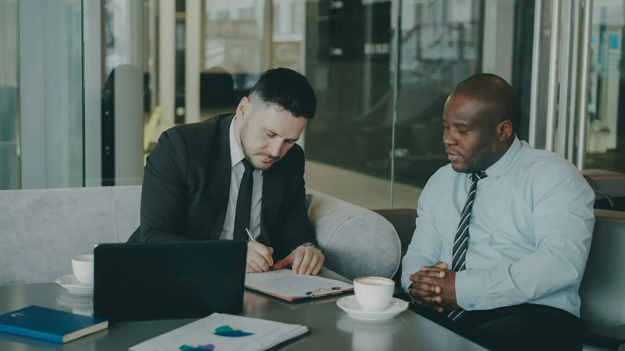 Two directors reviewing and signing documents at a table