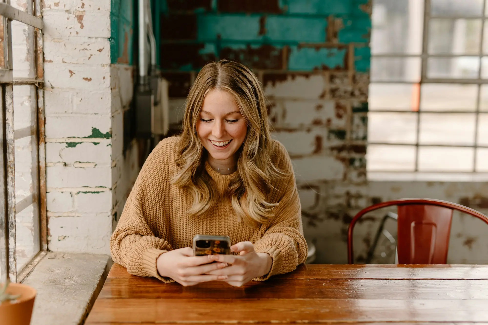 Business owner reading on her phone at a cafe table