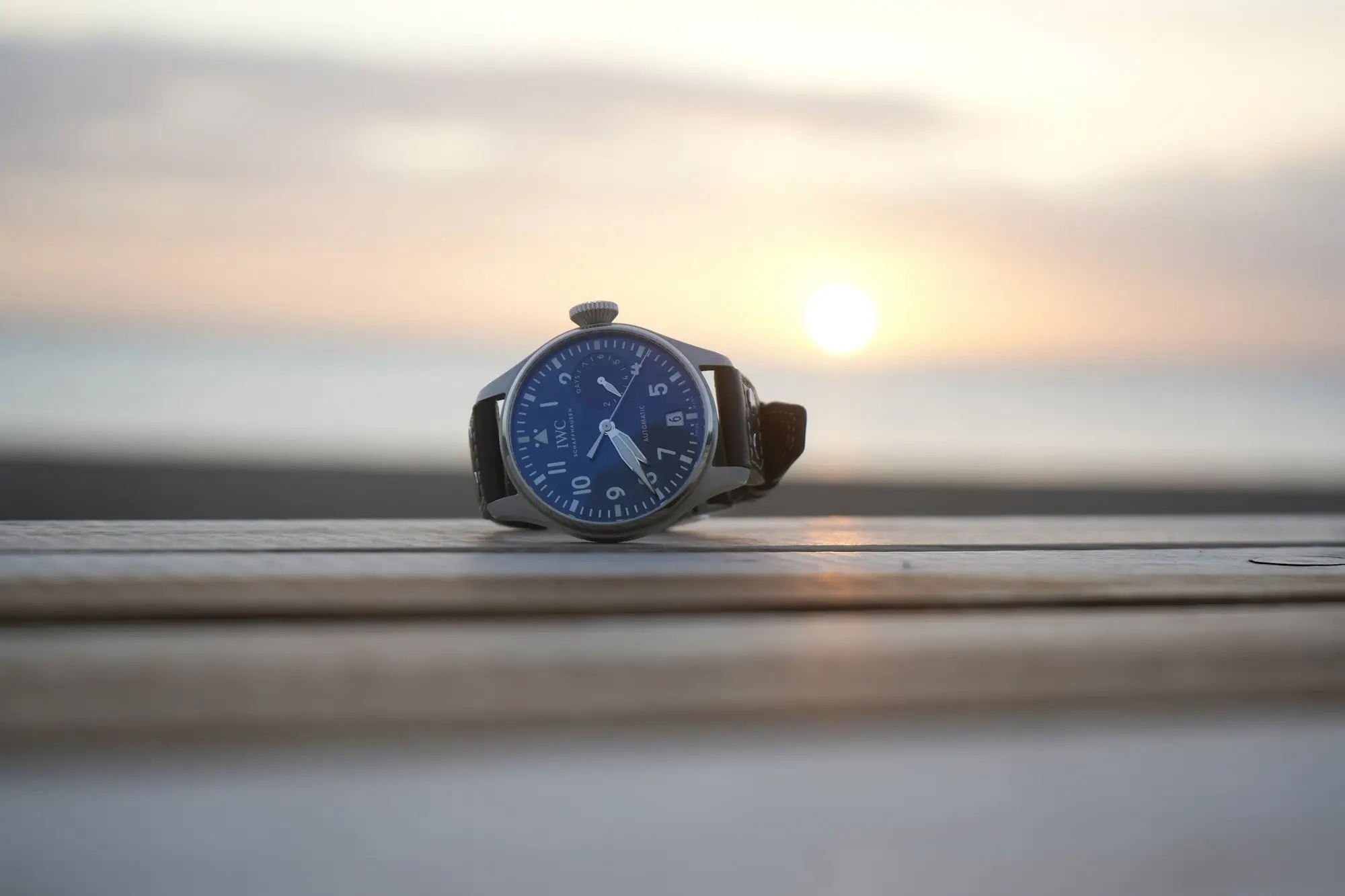 Wristwatch on a ledge at sunrise marking the start of the business day
