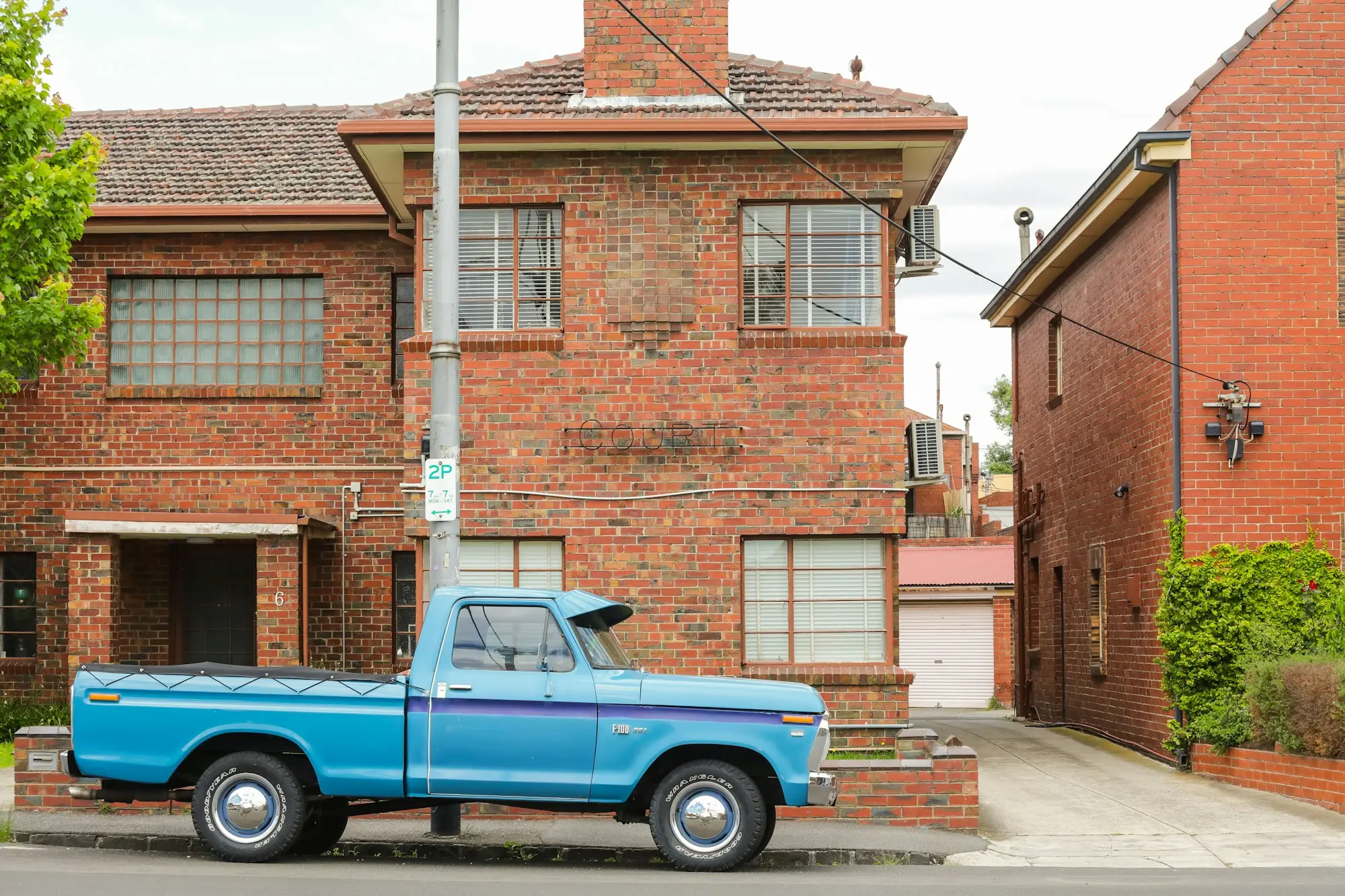 Vintage ute parked outside brick flats in Melbourne