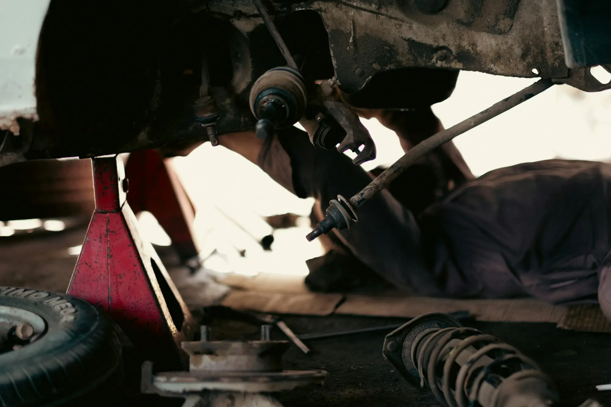 Mechanic working underneath a truck in a repair workshop